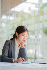 Accountant. Smiling beautiful Asian woman working on finances and calculators in office, accounting concept, vertical photo.