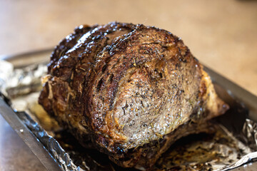 A large prime rib beef roast that was baked and roasted in the oven by a home gourmet chef for a holiday Christmas dinner