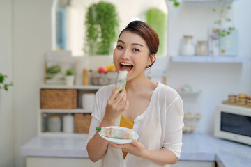 woman eating healthy spring roll