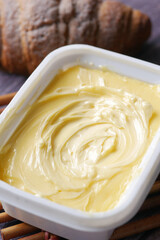fresh butter in a container with bread on white background 