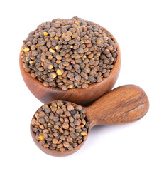 French lentils in wooden bowl and spoon, isolated on white background. Dry puy lentil grains pile.