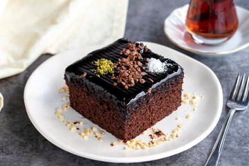 Wet cake. Pastry product. Cake with chocolate sauce on dark background. Close-up
