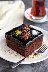 Wet cake. Pastry product. Cake with chocolate sauce on dark background. Close-up