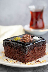 Wet cake. Pastry product. Cake with chocolate sauce on dark background. Close-up