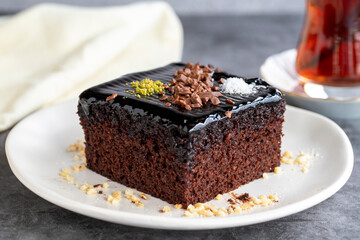 Wet cake. Pastry product. Cake with chocolate sauce on dark background. Close-up