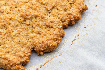 クッキングシートの上の焼きたてオートミールクッキー
