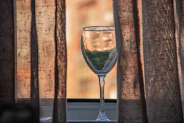 Glass of water near the window on the background of a high-rise building