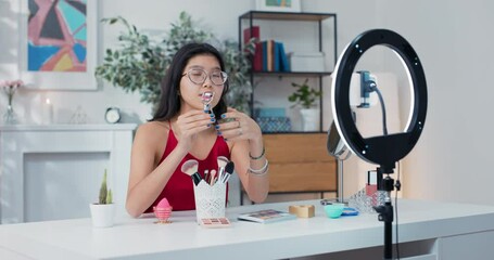 Beauty blogger shows off an eyelash curler to a live camera audience. A girl explains how to properly use makeup accessories. Influencer reveals the secret to beautiful lashes.