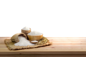 Fototapeta na wymiar Asian uncooked white rice and burlap sack on wooden table isolated on White Background.