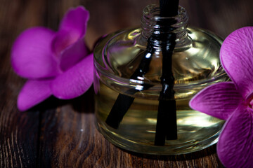 aroma diffuser and rattan sticks on dark wooden background, spa attributes