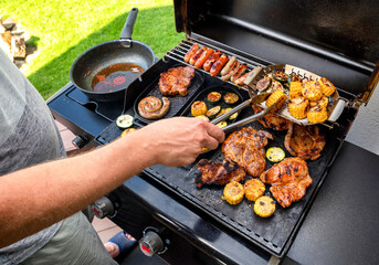 man is making grill barbecue outdoors on the backyard. Bbq party