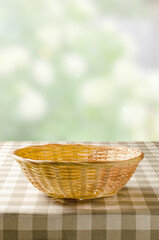 Fototapeta na wymiar A table with a napkin and a wicker basket for food. Blurry summer or spring background