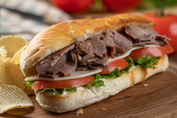 Submarine sandwich with roast beef, cheese, tomato and lettuce