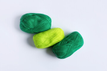 Green yarn threads on a white background for knitting. Flat lay