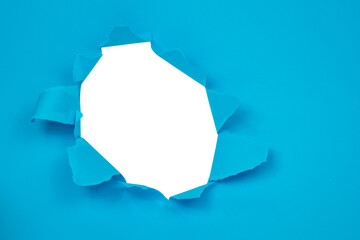 Hole in paper blue background torn damaged for design