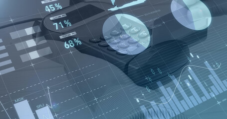 Image of graphs and financial data over hand of caucasian man holding payment terminal