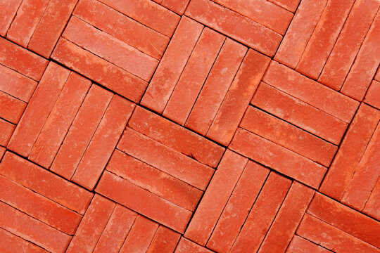 The geometric background and texture are made of natural red brick.The folded pattern of brickwork.Sidewalk in the garden