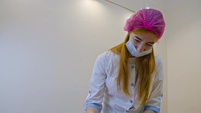 Beauty and injection concept. Cosmetology in the clinic. An experienced beautician wearing white gloves injects subcutaneous injections with the necessary active ingredients into the woman's back for
