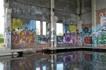 abandoned building with painted mills and flooded with water