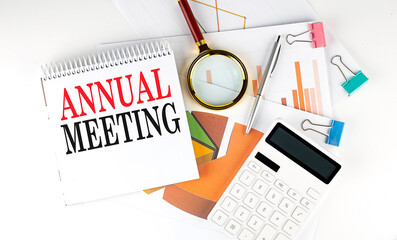 White notepad text ANNUAL MEETING with diagram,chart,calculator on the white background