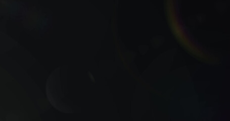 Image of white light with beam and prismatic lens flare on black background