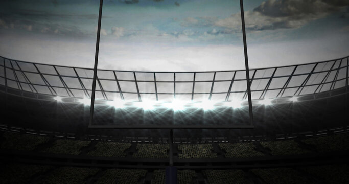 Image of american football goalposts and cloudy sky at floodlit stadium