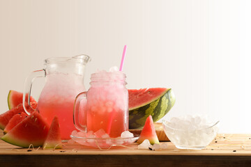 Glass and pitcher with watermelon drink on wooden table isolated