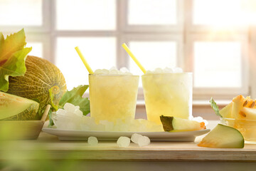 Two glasses with iced melon drink with window in background