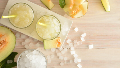 Two glasses with iced melon drink on plate top view