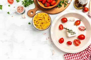 cooking recipe Fetapasta with cherry tomatoes, feta cheese, garlic and thyme on white plate. top view