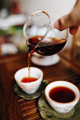man pours tea with one hand