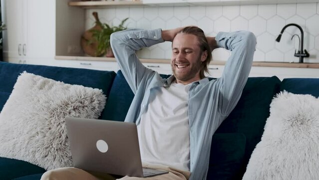 smiling man looking at the screen delighted with satisfying results or achievements. Positive tendency. Working online, positive statistics.