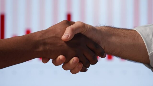 Two business partners shaking hands in modern office