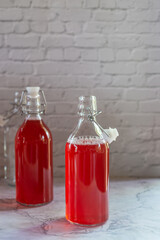 homebrew rose Kombucha in swing top glass bottle on white table background., fermented tea drink, healthy beverage.