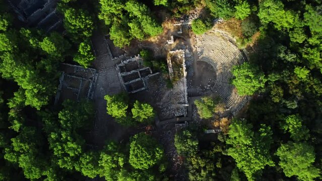 Top drone view of stone ruins of an amphitheater near the old town Phaselis. National Turkish landmark on the Mediterranean coast. Aerial view of natural reserve and tourist attraction. Travel concept