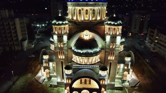 Backwards reveal shot of the illuminated Orthodox cathedral in the centrum of Deva, Romania.