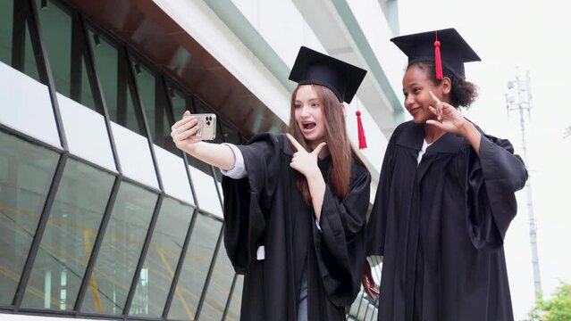 student wearing gown and making photo by smartphone  graduating. Happy graduate success and celebration. Congratulation