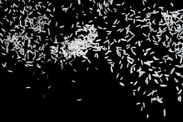 Raw white rice explosion. Heap of raw rice on dark background. faling rice on black background