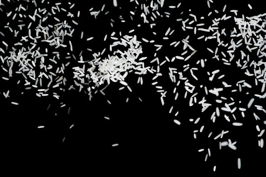 Raw white rice explosion. Heap of raw rice on dark background. faling rice on black background - Powered by Adobe