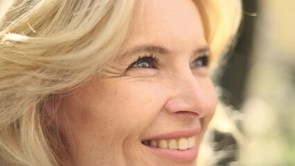 Portrait of attractive middle aged woman on the city street. Happy relaxed lady looking ahead on the city centre enjoying.