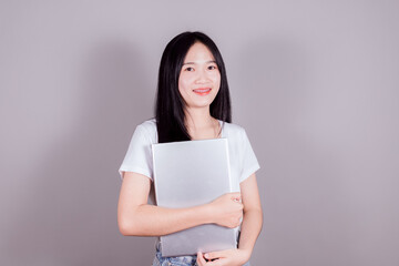 Portrait of happy young asian girl using laptop computer on gray background