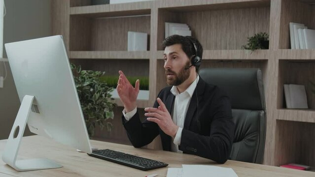 Smart-looking and representive middle-aged business consultant leads a session online conference from his office