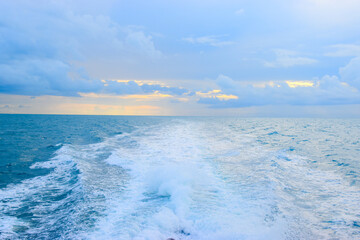 Naklejka na ściany i meble The wake from a boat at sea during sunset