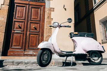 italian vespa is parked close to a house entrance