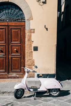 italian vespa is parked close to a house entrance