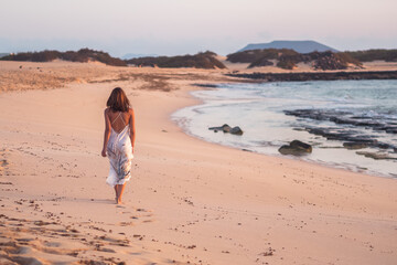 Free woman walking in bare foot at the beach