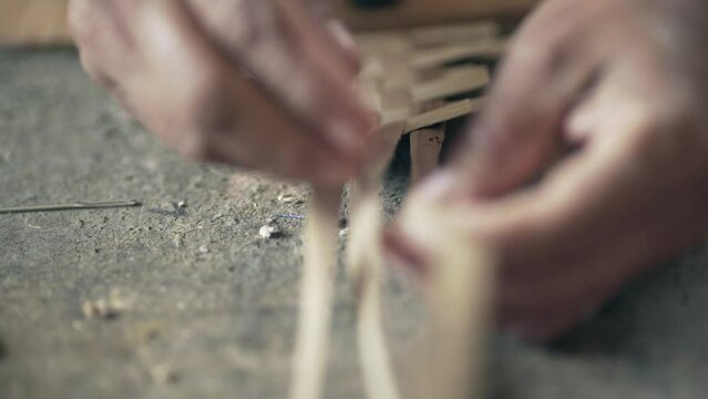 Woman´s hand weaving an ancestral basket case. Close up