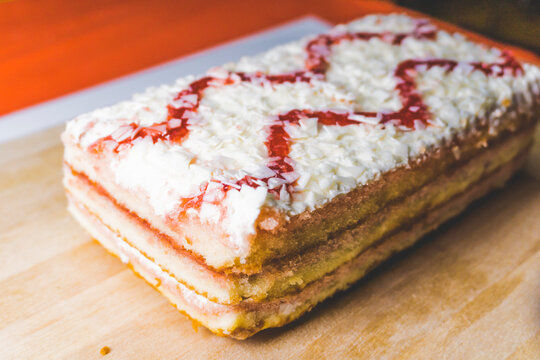 Raspberry cake with white chocolate, on a wooden board, indoor photo
