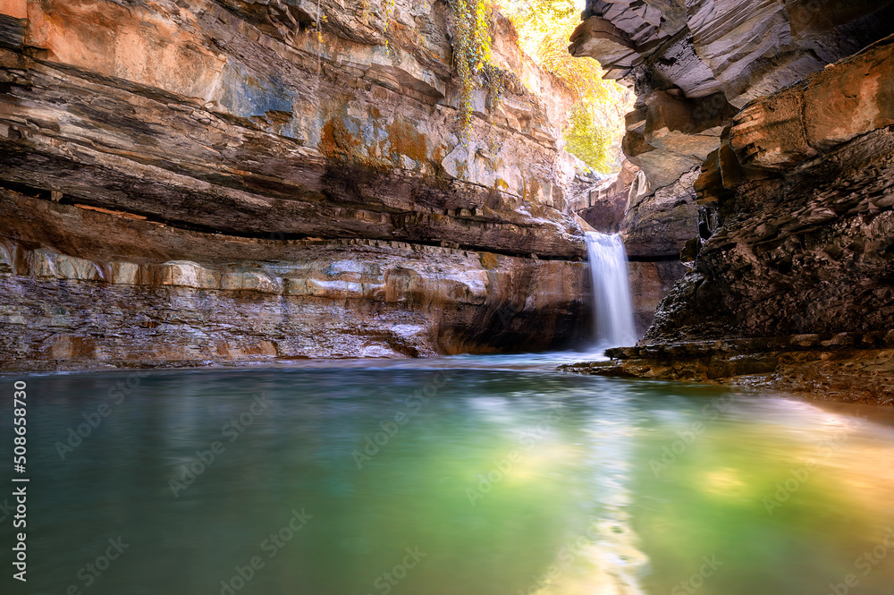 Wall mural italy, 2 june 2022. wonderful waterfall in premilcuore surrounded by nature with rocks, in long expo