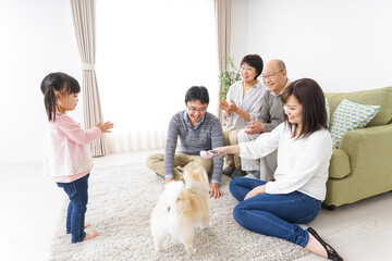 Three-generation family playing with dog